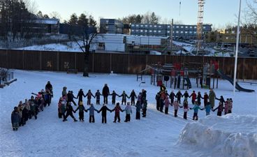 en gruppe mennesker som står i snøen