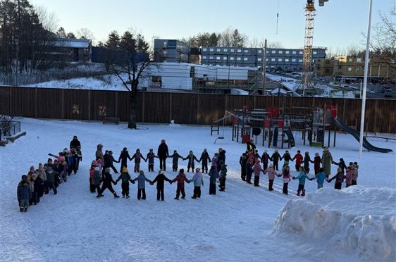 en gruppe mennesker som står i snøen