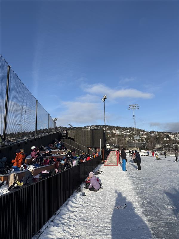 En gruppe mennesker som ser på en snowboarder på en rampe